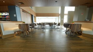 A spacious lobby with a central seating area, wooden flooring, and a reception desk with a beverage display. - Holiday Inn Express Asuncion Aviadores by IHG (Asunción)