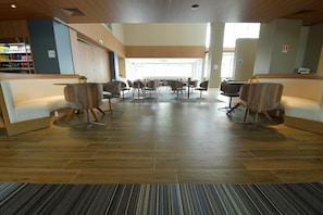 A spacious lobby with a central seating area, wooden flooring, and a reception desk with a beverage display. - Holiday Inn Express Asuncion Aviadores by IHG (Asunción)