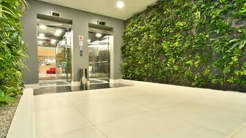An indoor area with a green wall, a reception desk, and an elevator.