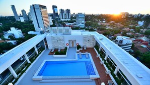 A rooftop pool with a view of the cityscape, including modern buildings and a sunset. - Holiday Inn Express Asuncion Aviadores by IHG (Asunción)