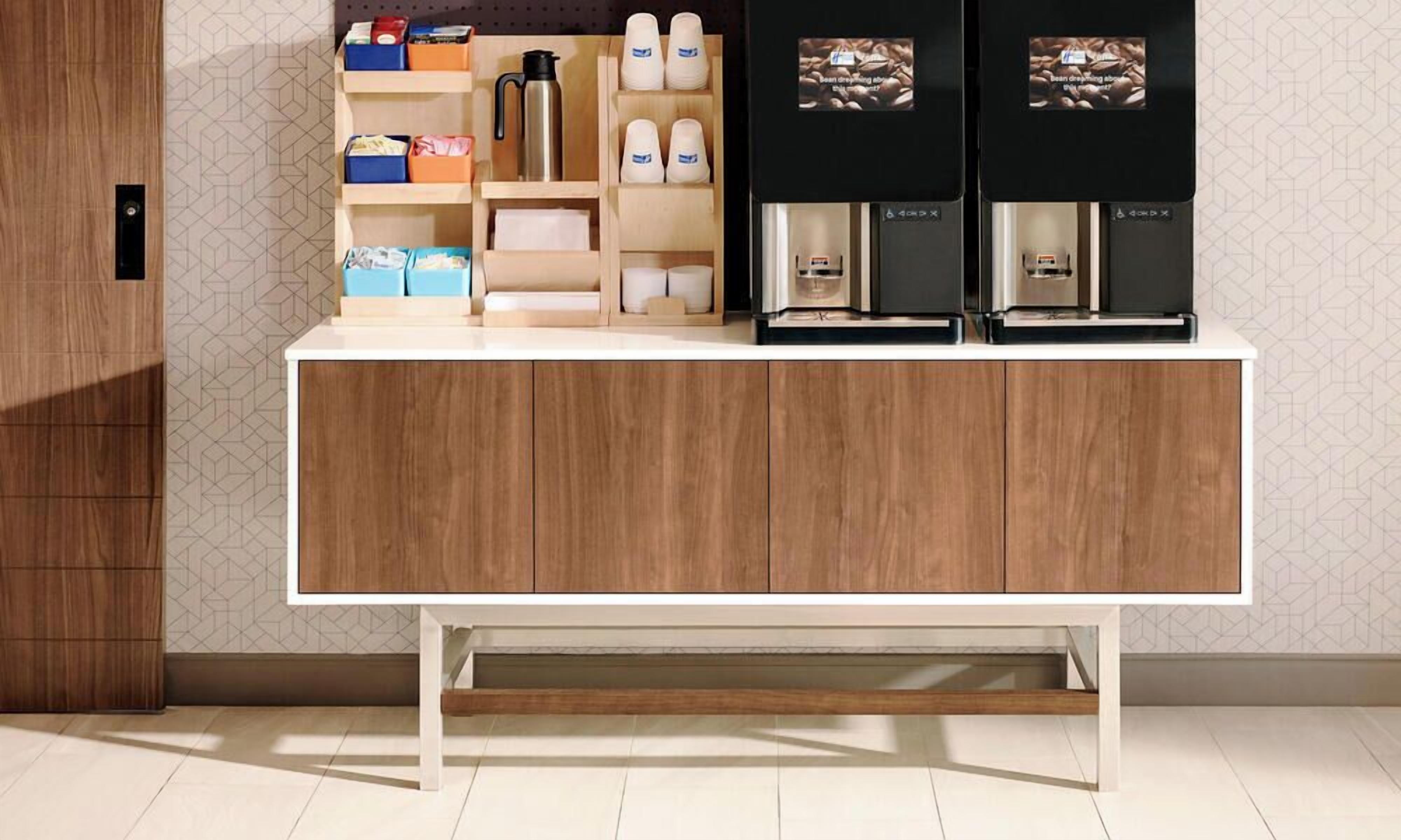 Una cocina moderna con un mueble de madera, una cafetera y cajas de almacenamiento.
