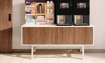 Una cocina moderna con un mueble de madera, una cafetera y cajas de almacenamiento.
