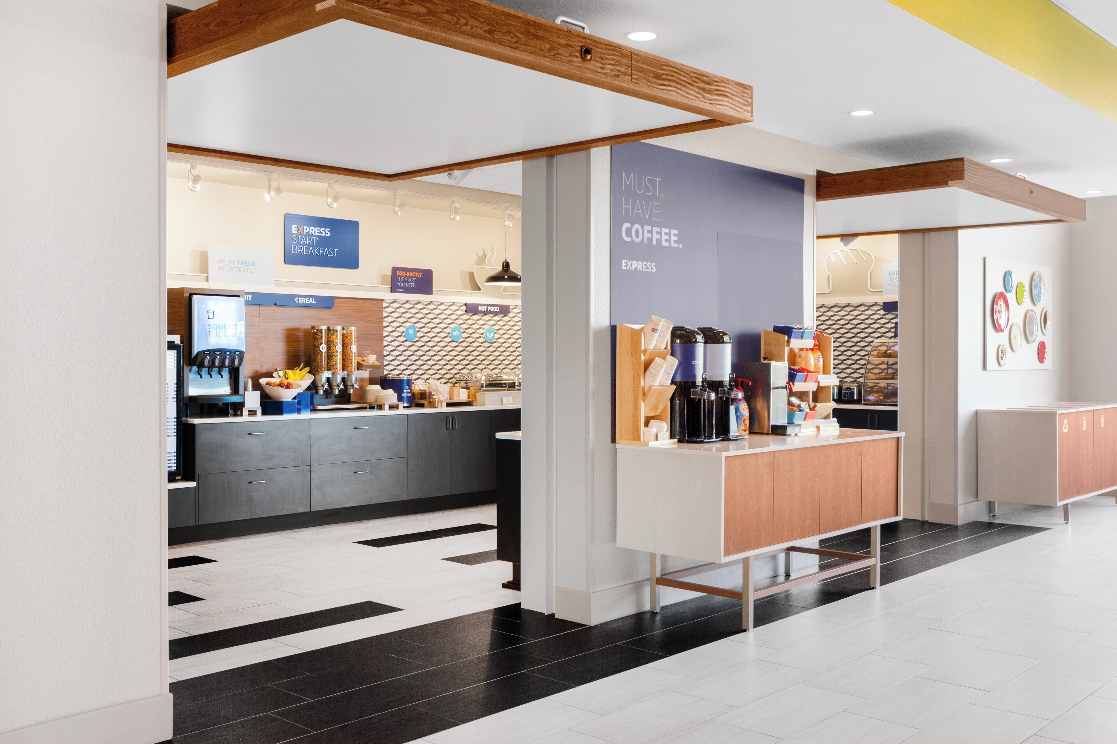 Un café moderne avec un comptoir, des machines à café et une enseigne indiquant « Petit-déjeuner express ».