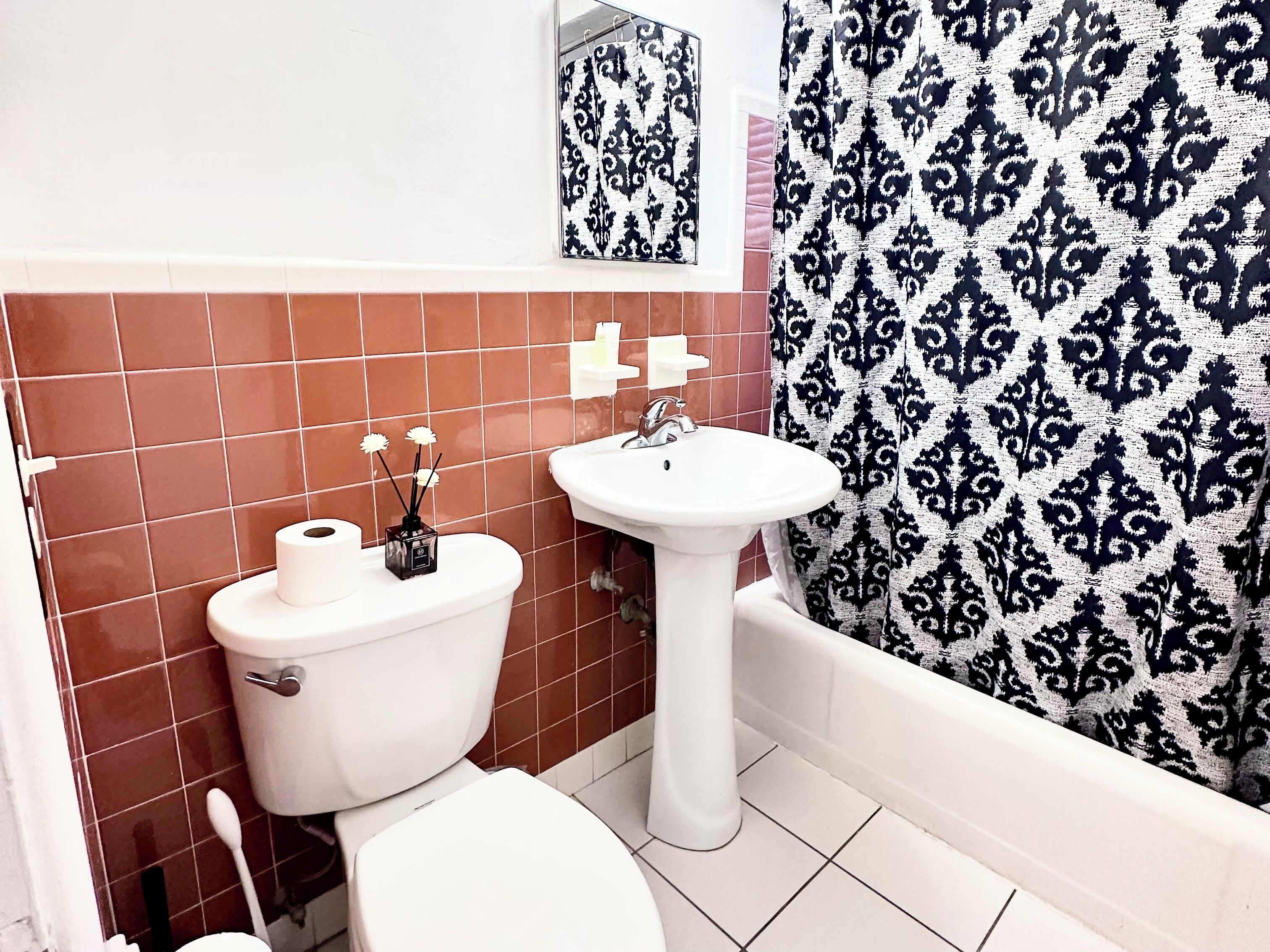 Une salle de bain avec des toilettes, un lavabo et un rideau de douche.