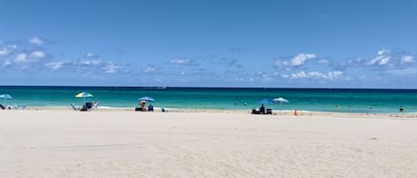 On the beach, white sand, beach umbrellas, beach towels