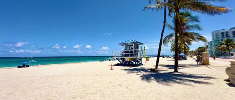 Am Strand, weißer Sandstrand, Sonnenschirme, Strandtücher