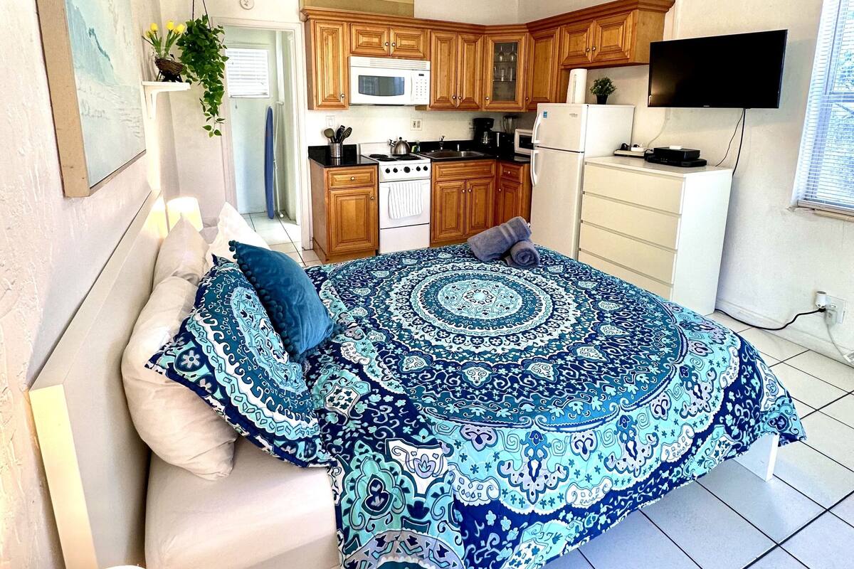 A bedroom with a bed, bedside table, and a ceiling fan.