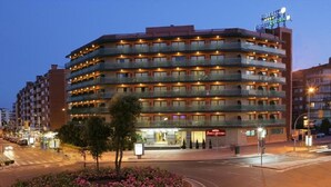 A multi-story hotel with balconies, a garden, and a sign indicating it is a hotel. - Fenals Garden (Lloret de Mar)