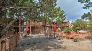 Un hotel con terraza al aire libre, cubierta de madera y patio amurallado.