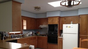 A kitchen with wooden cabinets, a microwave, an oven, and a refrigerator. - Quiet Waterfront House Sleeps10, Plenty Of Parking, Boat Slip (Rehoboth Beach)