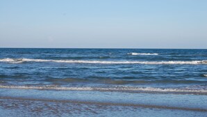 Una playa con olas y un cielo despejado.