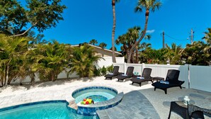Un espace piscine avec des chaises longues et un jacuzzi.