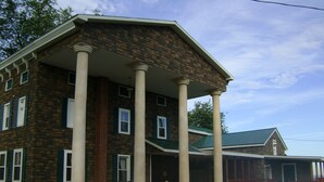 A two-story building with a brick facade and a covered porch supported by columns. - Room #6 We are only 30 min. away from  "BASEBALL HALL OF FAME" in Coopers Town . (Fort Plain)