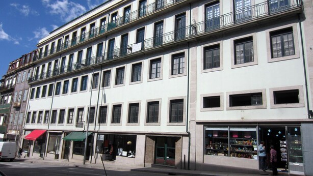 A multi-story building with a row of shops on the ground floor. - House of the Cathedral - 2 bedroom apartment near the Cathedral (historic center) (Porto)