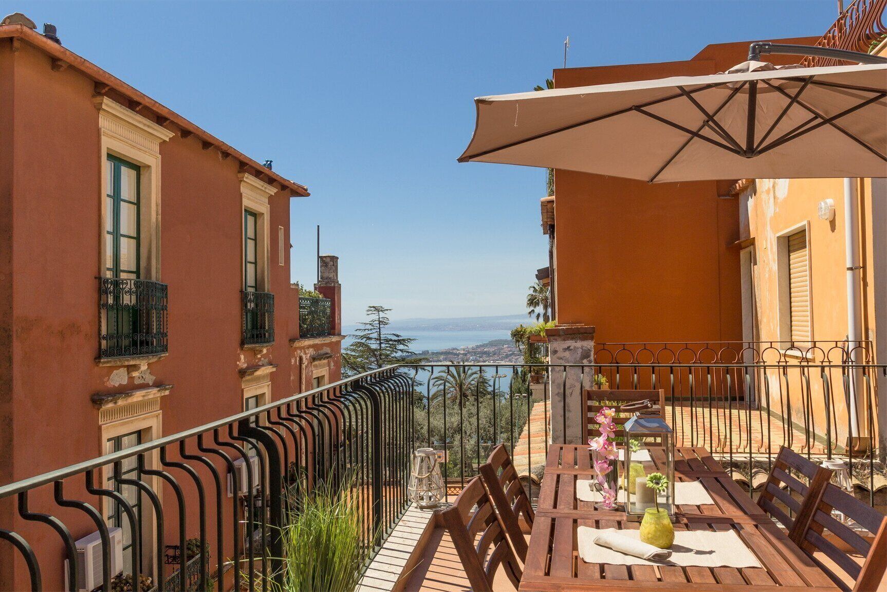 A balcony with a table and chairs, overlooking a scenic view.