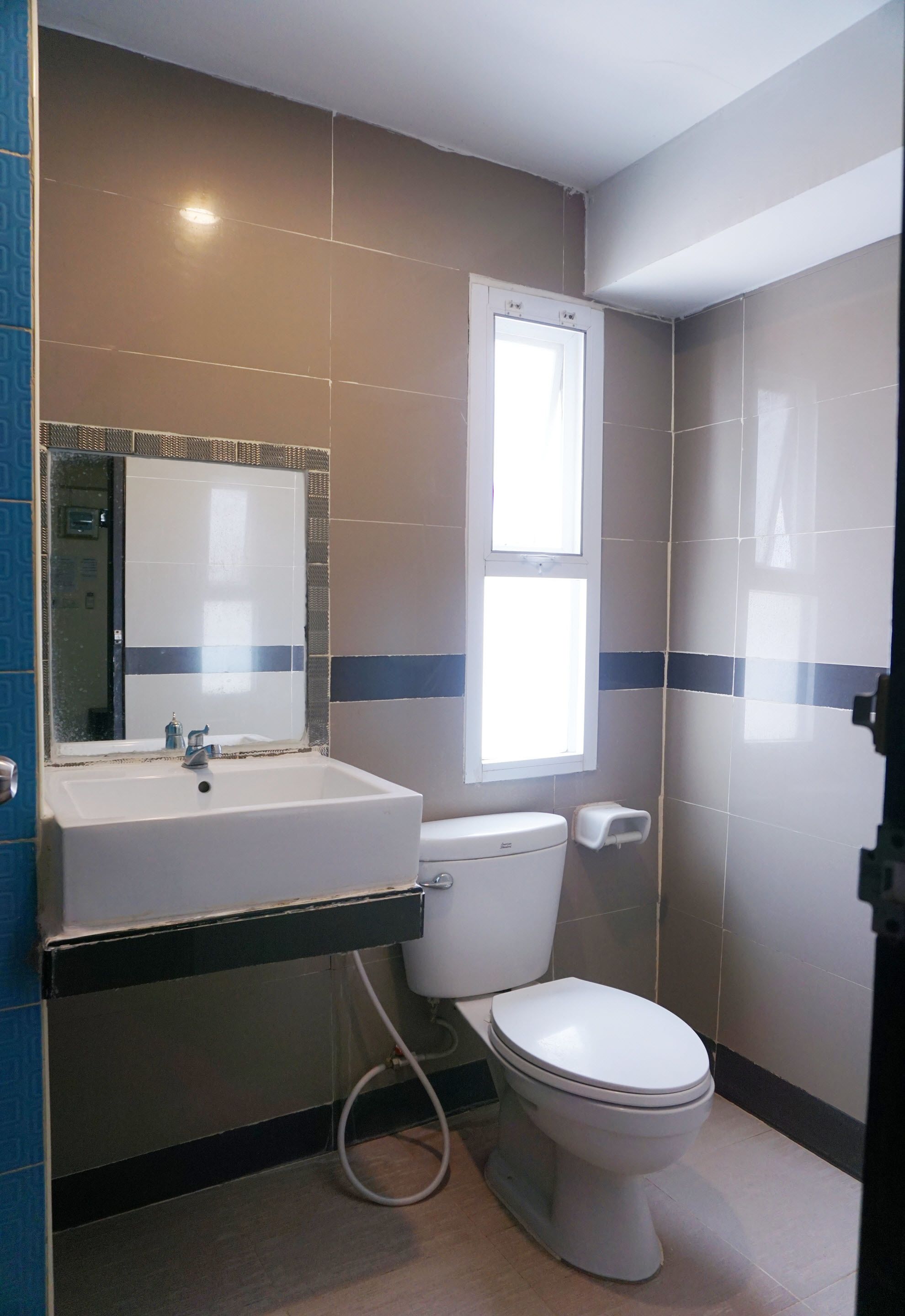 A bathroom with a white sink, a toilet, and a mirror.
