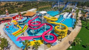 A water park with multiple slides and pools, surrounded by palm trees and a clear sky. - Luxury villa, with garden and private pool, A/C, free WiFi, near beach (Albufeira)