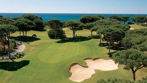 A golf course with a clear view of the ocean, surrounded by dense trees. - Luxury villa, with garden and private pool, A/C, free WiFi, near beach (Albufeira)