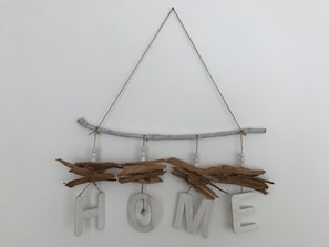 A rustic wall hanging with the word "HOME" and wooden elements.