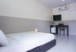 Une chambre d’hôtel équipée d’un lit, d’un bureau, d’une chaise et d’un téléviseur.