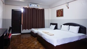 A hotel room with two beds, a wooden floor, a ceiling fan, and a wall-mounted air conditioner. - Puangpech Hotel (Lampang)