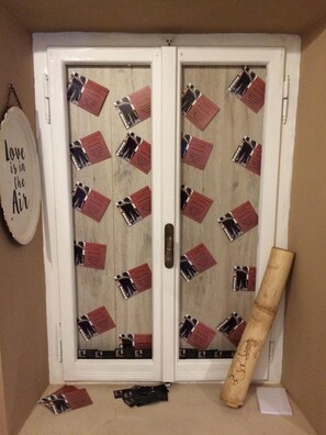 Una puerta decorada con un diseño de cartas rojas y negras, un bate de madera y un letrero que dice "Love is in the Air".