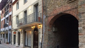 A building with a stone facade, a wooden door, and a balcony with wrought iron railings.