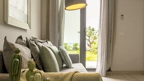 Un salon moderne avec un canapé, de nombreux coussins et une composition de cactus.