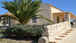 A stone building with a tiled roof, a palm tree, and a stone staircase leading to a covered area. - GRECALE Studio 2/3 sleeps with Pool - Modica - Sicily (Modica)