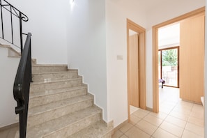 Un escalier avec une rampe menant à une porte.