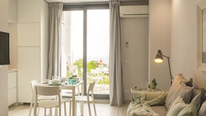 Ein modernes Wohnzimmer mit Essbereich, einer Couch und einem Tisch für zwei Personen.