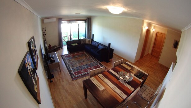 A spacious living room with a dark-colored sofa, a wooden coffee table, and a patterned rug. - Quinta do Anjo Apartment (Palmela)