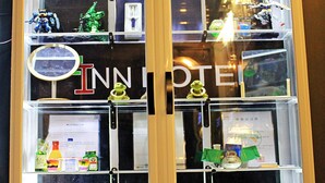 Une vitrine exposant divers objets, notamment une maquette de navire, des figurines et des certificats.
