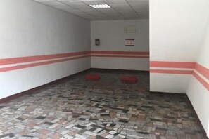 Un couloir doté d’un sol à motifs, de touches de rouge sur les murs et de deux bancs rouges.