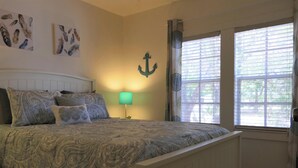 A bedroom with a bed, nightstands, a lamp, and artwork on the walls. - A dream vacation at a low price: Get huge discounts on travel now! (Fort Myers)