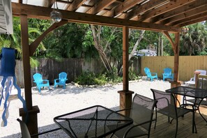 Relax in a serene outdoor space surrounded by lush greenery and a wooden pergola.