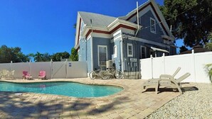 Ein Garten mit Swimmingpool, Gartenmöbeln und einem Haus.