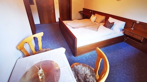 A bedroom with a bed, bedside tables, a chair, and a table. - Double room 1 incl. extended breakfast (room no. 4) - Weindlhof (Waidring)