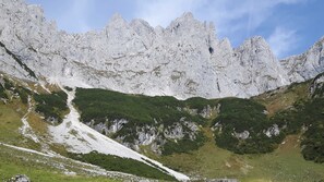 A mountainous landscape with rocky cliffs and green vegetation.