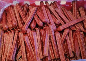 A pile of dried sausages in a plastic bag.