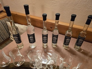 A table with six bottles of wine and several empty glasses.