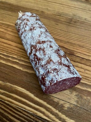 Ein längliches, rechteckiges Objekt mit weiß-brauner Musterung, auf einer Holzfläche platziert.