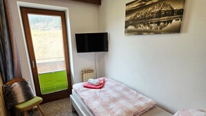A bedroom with a bed, a chair, a TV, and a painting. - Single Room - Weindlhof (Waidring)