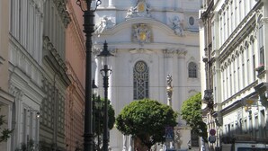 Un edificio histórico con arquitectura clásica, que incluye columnas ornamentadas y un reloj destacado.