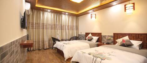 Habitación de hotel con dos camas, techo de madera, aire acondicionado de pared y ventana con cortinas.