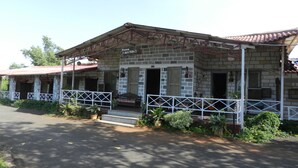 A building with a sign reading "Sawai MANSING" and a covered porch area. - Hotel Sawai Mansing Hill Resort (Shahuwadi)