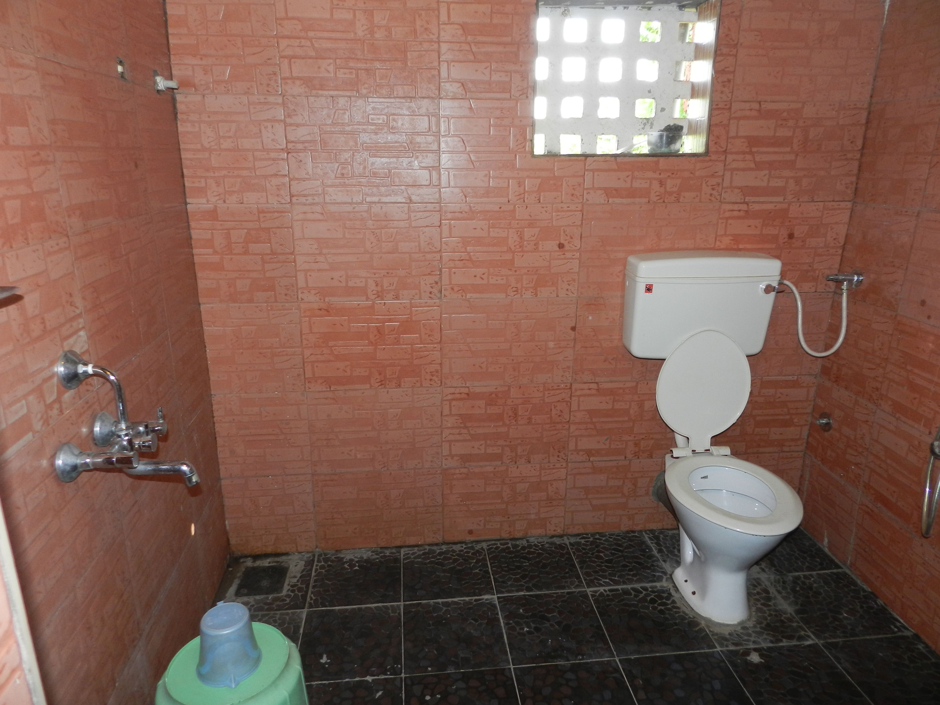 A small bathroom with a toilet, a sink, and a shower.