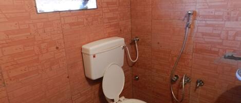 Un baño pequeño con inodoro, ducha y ventana.