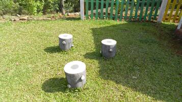 Three wooden posts on a grassy area with a green and white fence in the background.