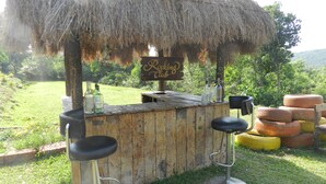 A rustic outdoor bar with a thatched roof, wooden stools, and a sign reading "Rocker Club". - Hotel Sawai Mansing Hill Resort (Shahuwadi)